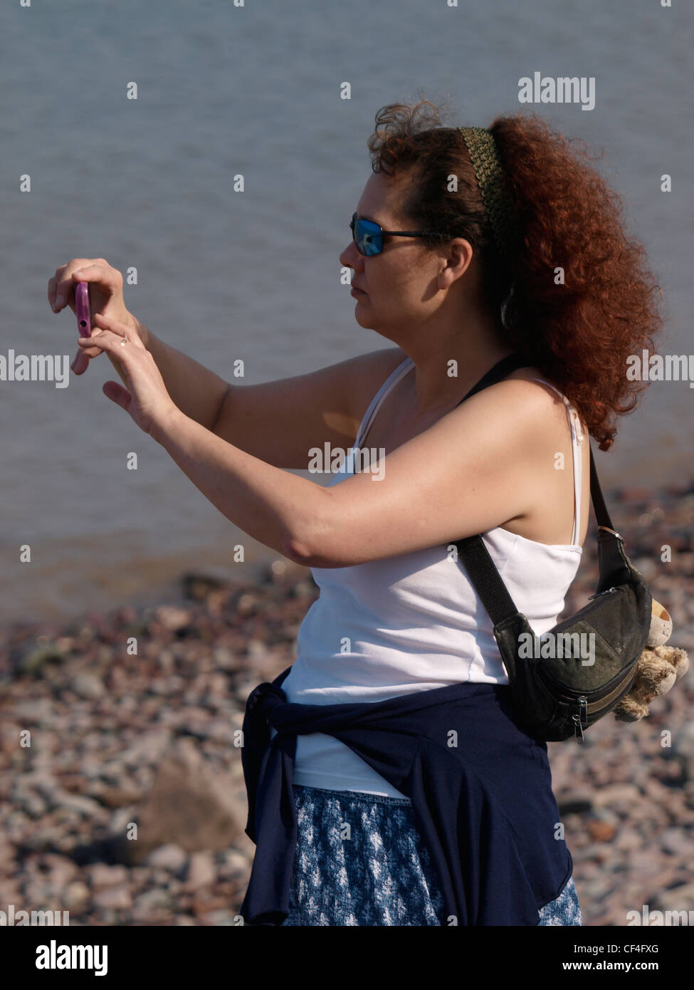 Vierzig plus Frau mit einem Kamera-Handy, UK Stockfoto