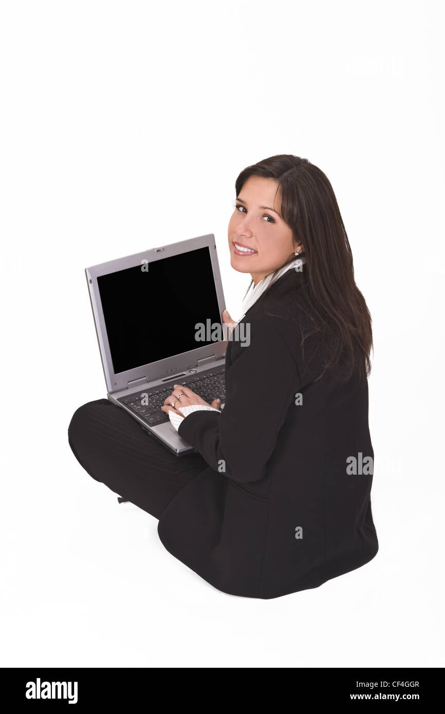 Geschäftsfrau mit einem Laptop auf dem Schoß sitzen und blickte zurück über die Schulter. Stockfoto