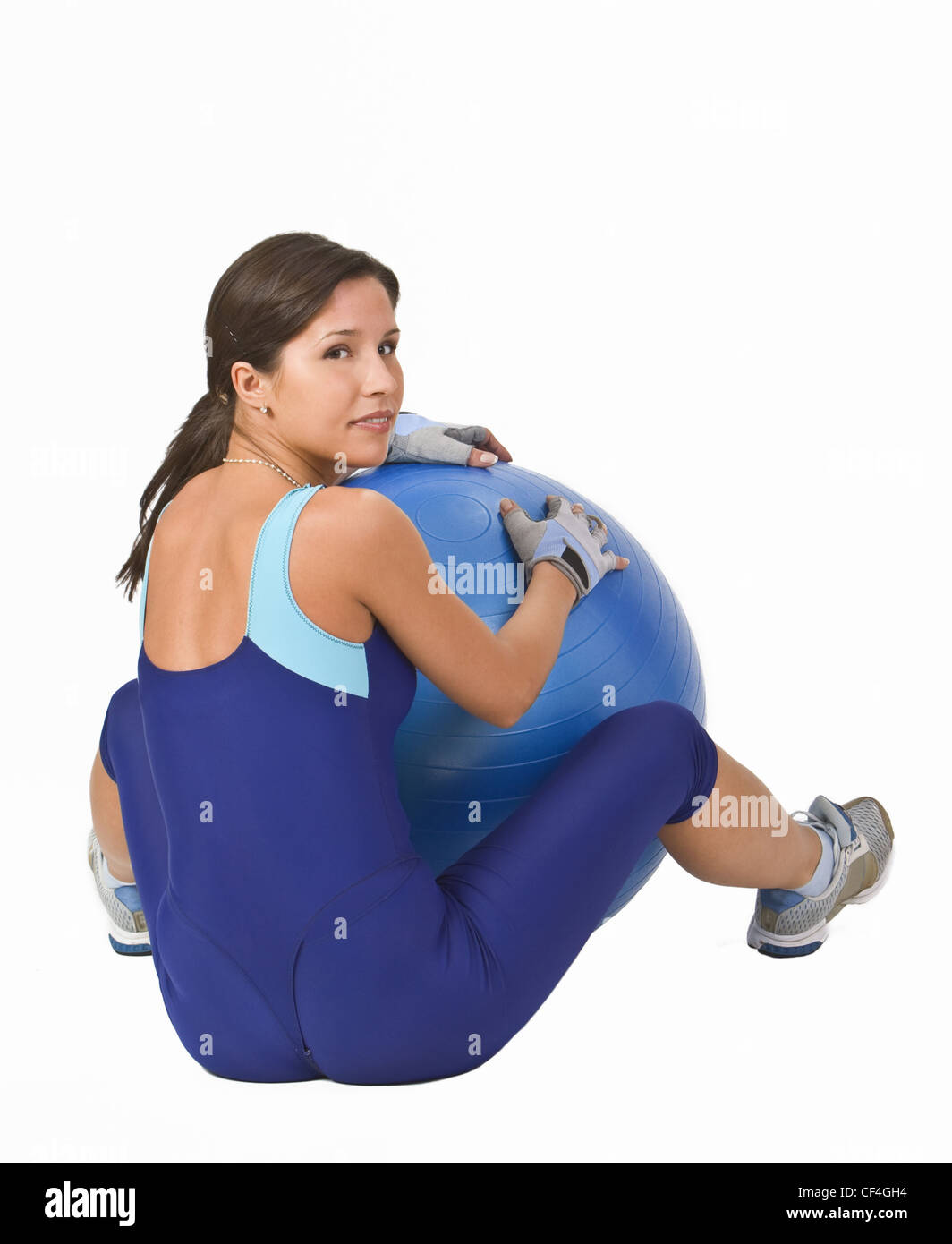 Frau sitzt mit einem blauen Gymnastikball. Stockfoto