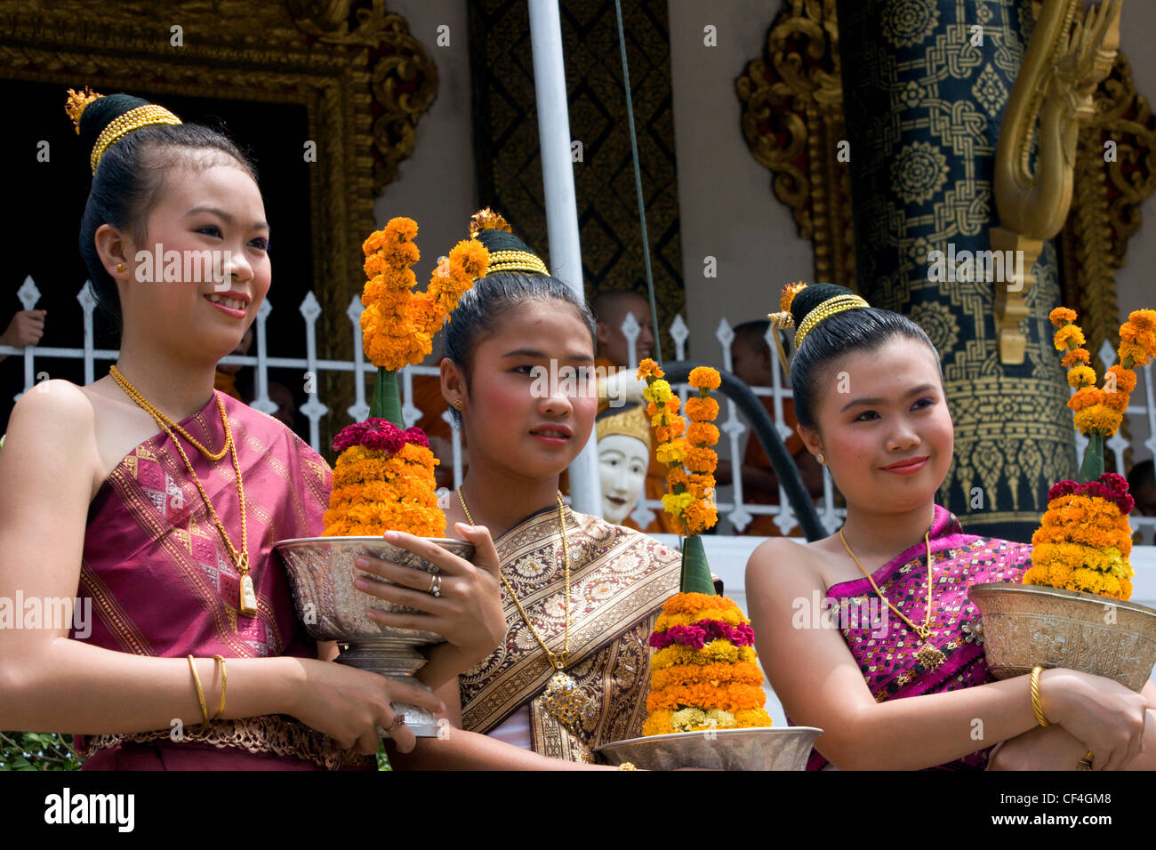 Junge asiatische Frauen halten Silberschalen mit Blumengirlanden auf dem Lao Neujahr New Year Festival in Luang Prabang, Laos. Stockfoto