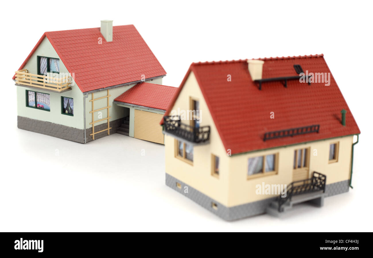 Modelle von zwei Häusern mit Garage für Auto auf weißem Hintergrund. Konzentrieren Sie sich auf die entfernten Haus. Stockfoto