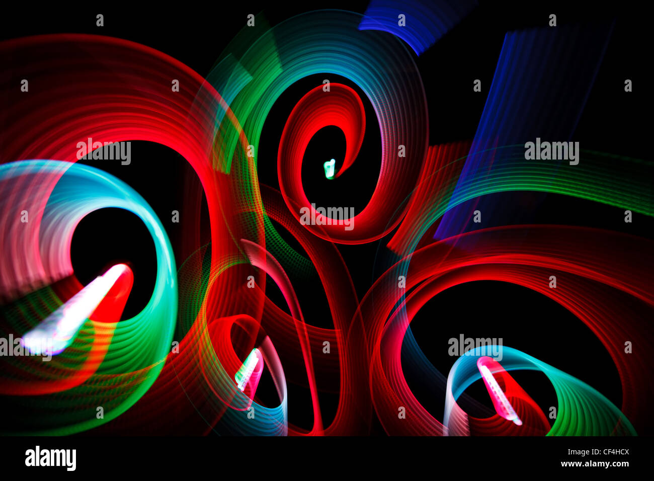 Abstrakte leuchtende Muster in Form von Spiralen auf schwarzem Hintergrund. Stockfoto