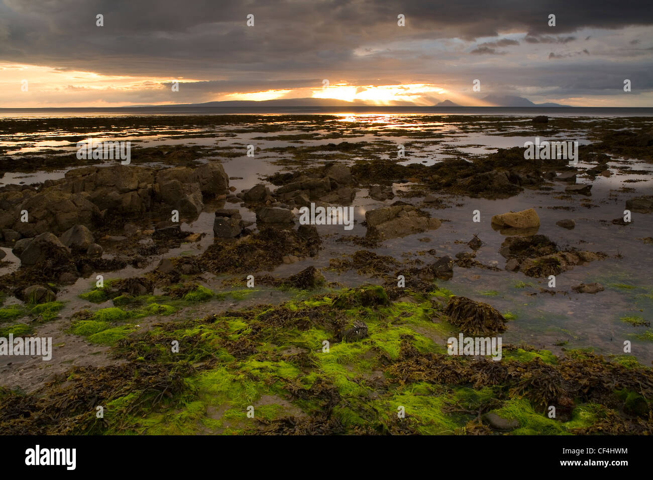 Ein Blick von der Küste von Culzean Bay in South Ayrshire. Die Isle of Arran und heilige Insel sehen Sie unter der Sonne Platzen der Stockfoto