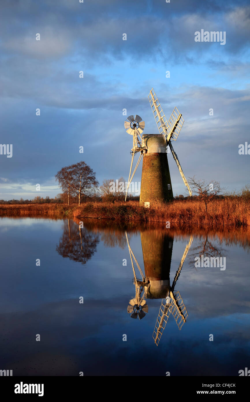 Ein Spiegelbild im Wasser des Turf Moor Wind Pumpe wie Hill auf den Norfolk Broads. Stockfoto