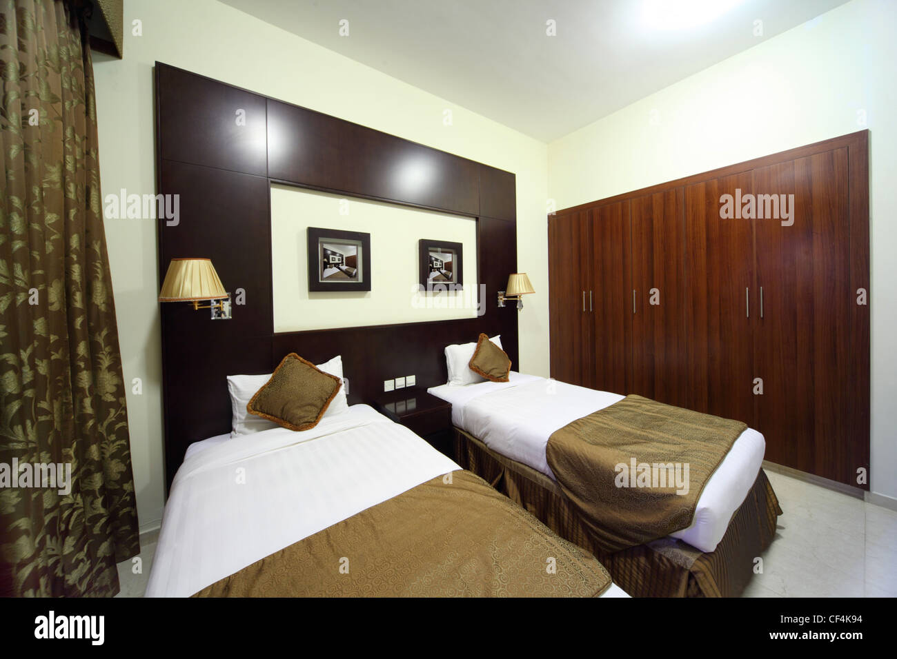 Schlafzimmer mit weißen Wänden, Kleiderschrank und zwei Betten Gesamtansicht Stockfoto