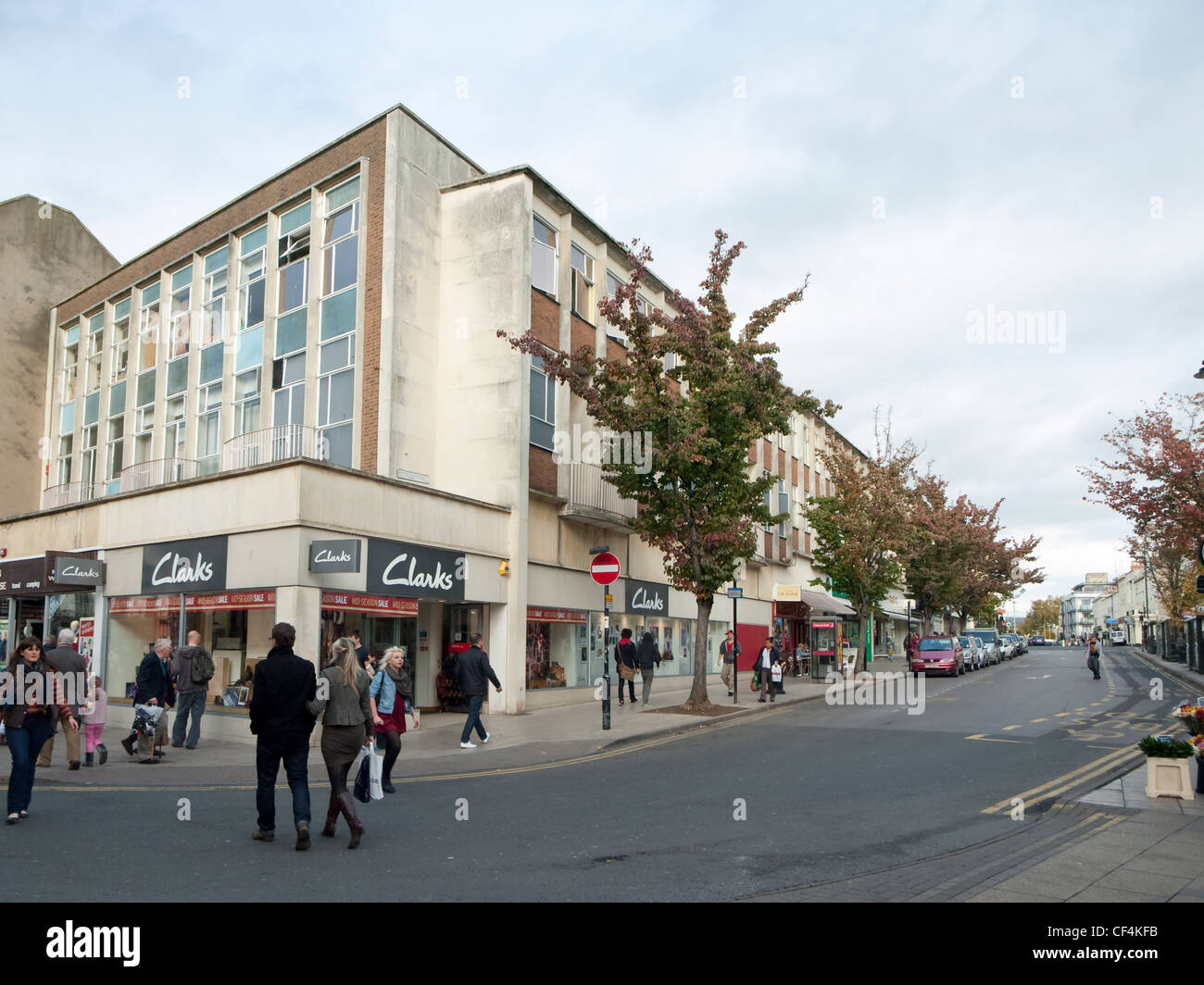 Pittville Street, Cheltenham, wo die Straße der Fußgängerzone Hohe Straße überquert. Mit dem Clarks schuh Shop an der Ecke Stockfoto