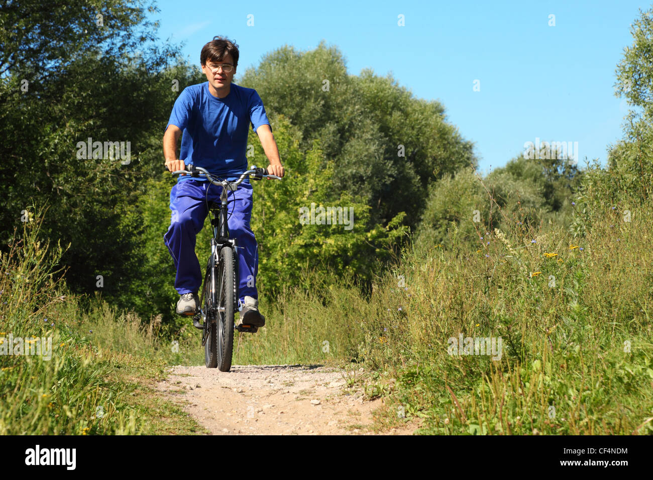 ein Mann tragen sportliche Kleidung reitet auf einem Fahrrad. Sommertag. Stockfoto