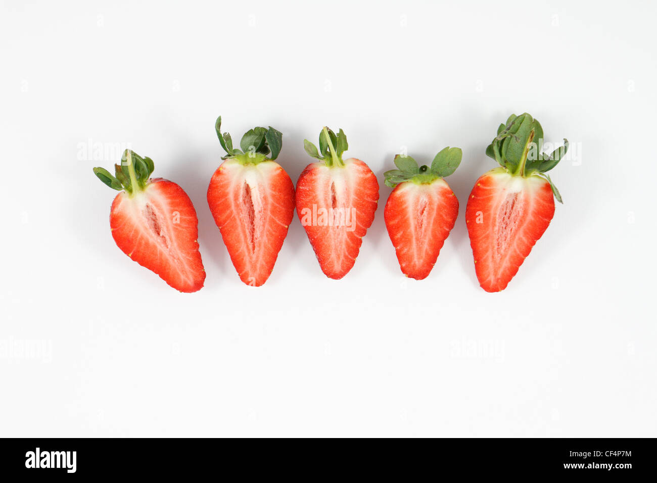 Halbierte Erdbeeren auf weißem Hintergrund. Stockfoto