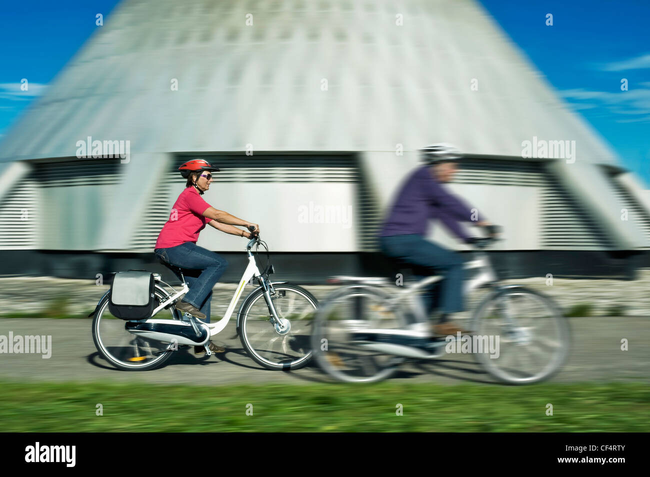 Deutschland, Bayern, Raisting, Senior paar Reiten Elektro-Fahrrad in der Nähe von Radiosender Stockfoto