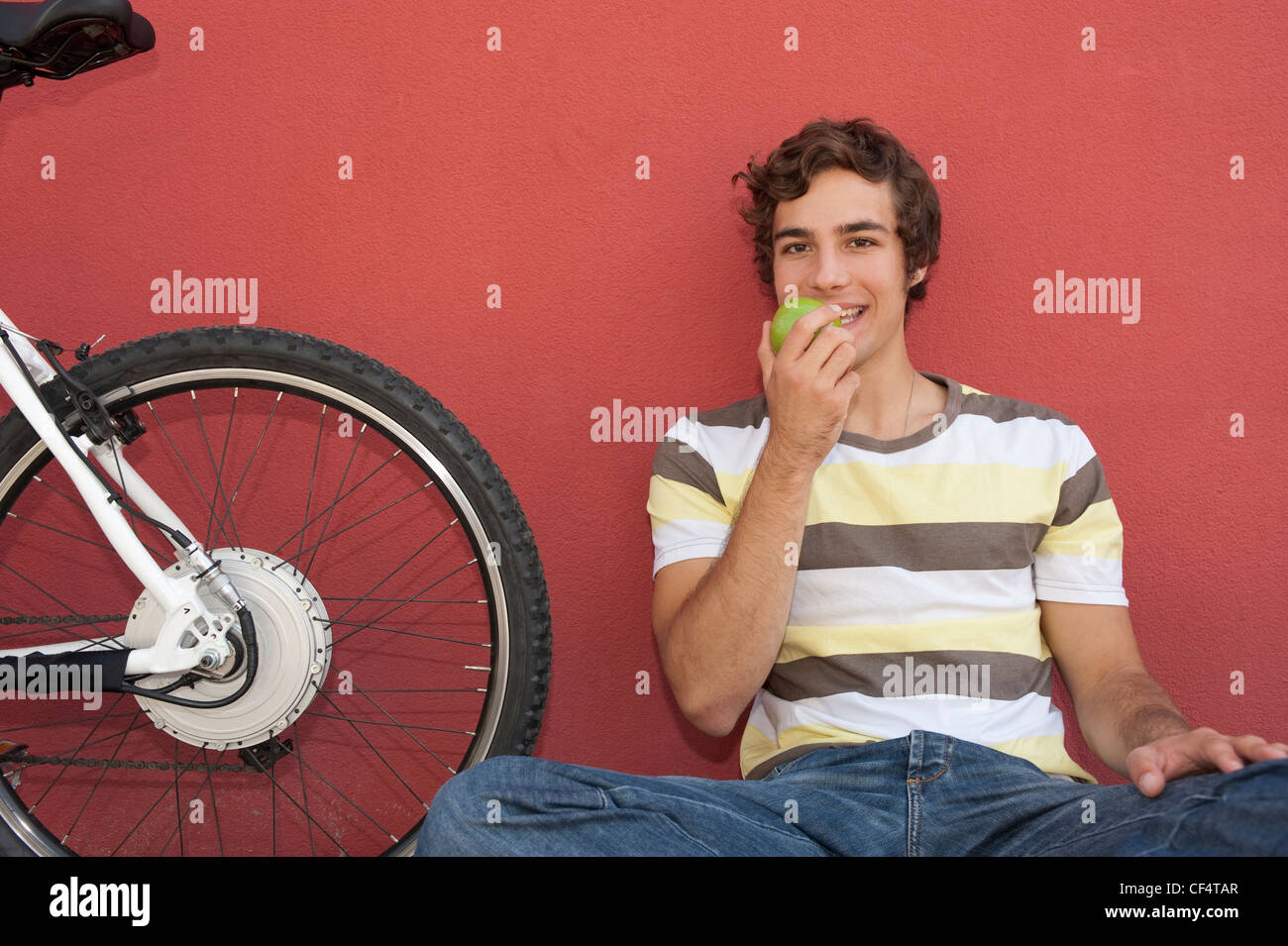 Deutschland, Bayern, junger Mann Essen Apfel, Lächeln, Porträt Stockfoto