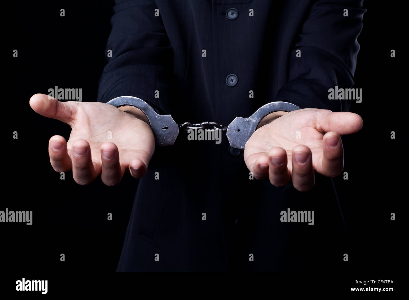 Business-Mann im schwarzen Anzug und Handschellen Stockfoto