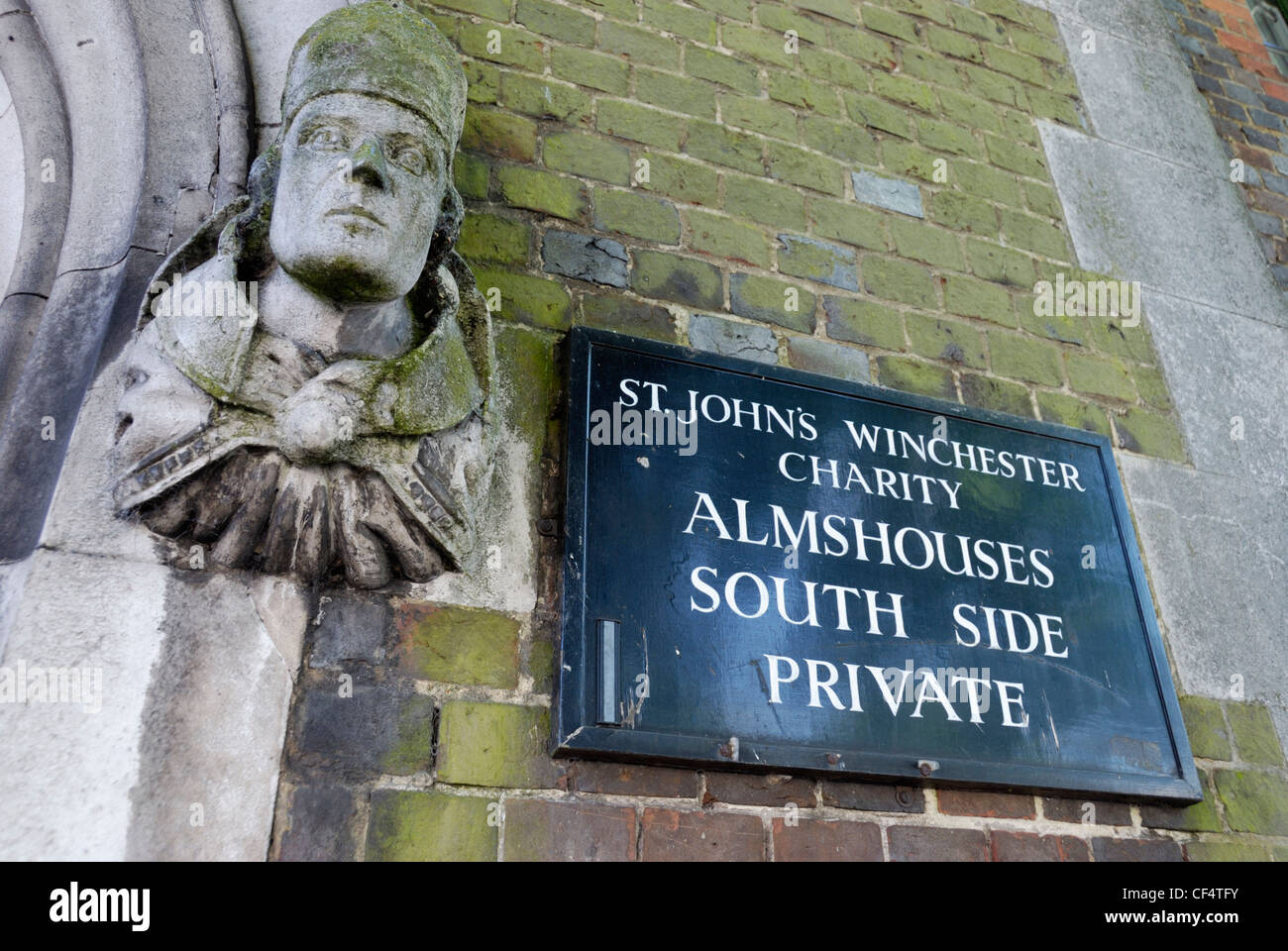 Statue und Schild am Eingang zum St. John Winchester Almosen Armenhäuser. Stockfoto