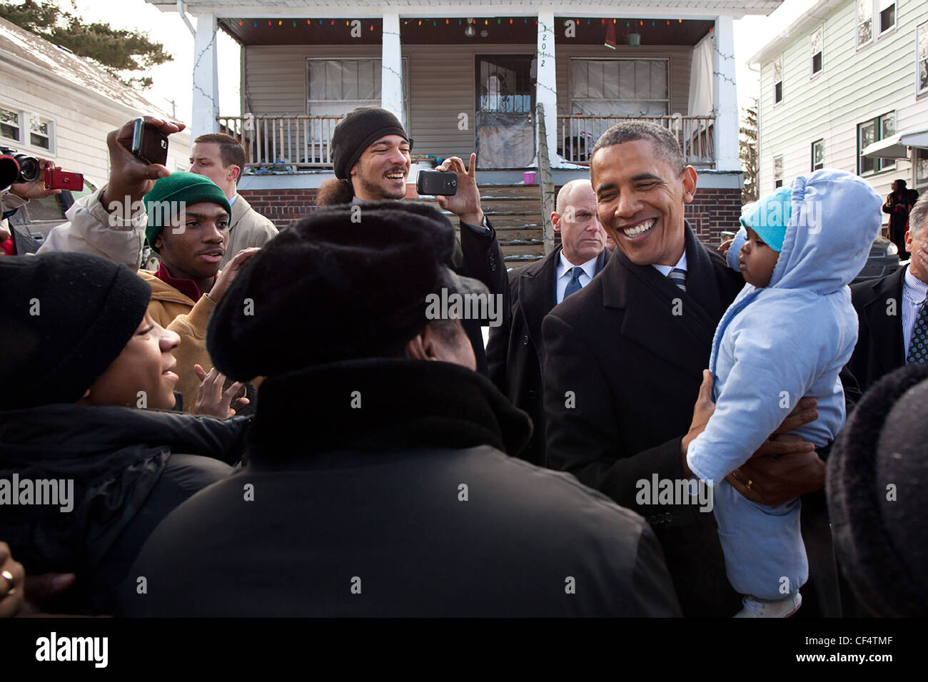 Präsident Barack Obama begrüßt Nachbarn außerhalb der Heimat von William und Endia Eason 4. Januar 2012 in Cleveland, Ohio. Der Präsident besucht die ründe, verloren fast ihre Heimat nach einem Sturz zum Opfer eines räuberischen Kreditgeber, um die Notwendigkeit für eine starke Consumer Financial Protection Bureau diskutieren. Stockfoto