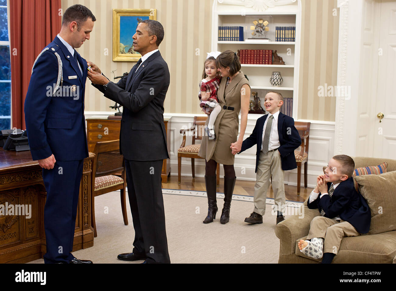 Mitglieder der Familie Preis beobachten, wie Präsident Barack Obama Defense Superior Service Medal präsentiert an ausgetretene Military Aide Oberstleutnant Sam Price im Oval Office, 9. Januar 2012 in Washington, DC. Stockfoto