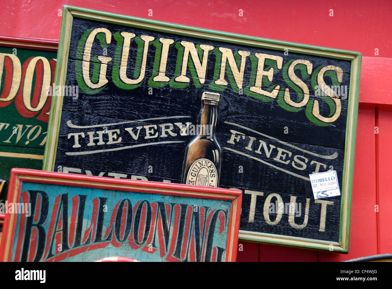 Eine alte hölzerne, hand bemalte Guinness-Werbeschild für Verkauf Ouside ein Antiquitätenladen in Portobello Road. Stockfoto