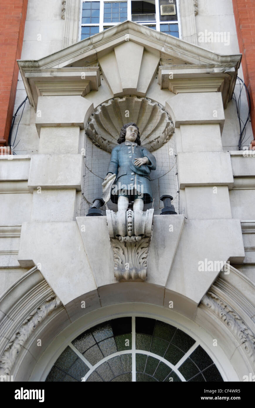 Statue von männlichen Blue Coat-Schüler an der Außenseite der Sir John Cass Foundation Primary School. Eine blaue Mantel-Schule war ursprünglich Stockfoto