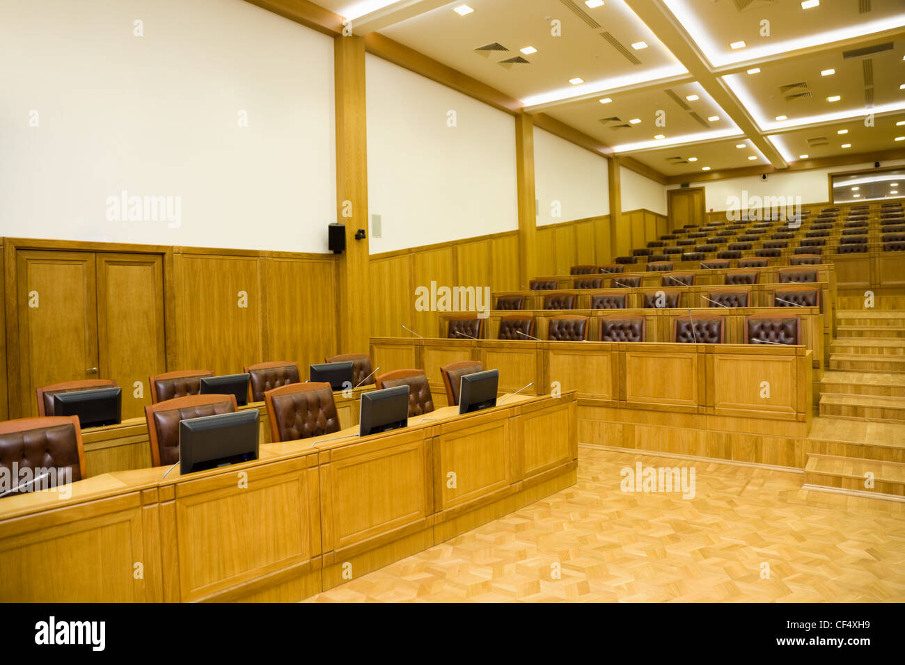 Seitenteil-Konferenz der Hallen mit prachtvollen Ledersesseln und Holztische mit Mikrofone und Monitore Stockfoto