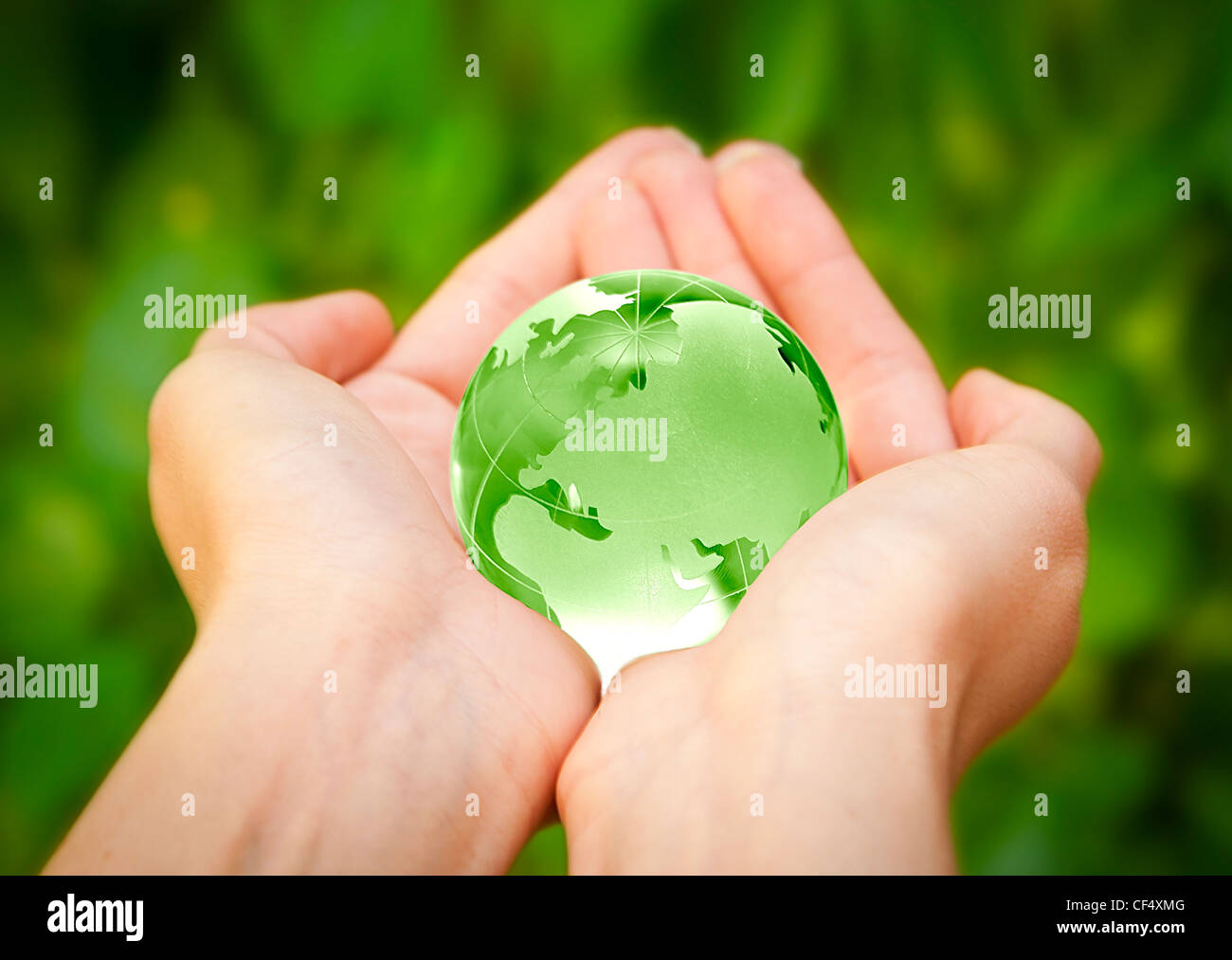 menschliche Hände sorgfältig mit Erde. Glas-Welt Stockfoto