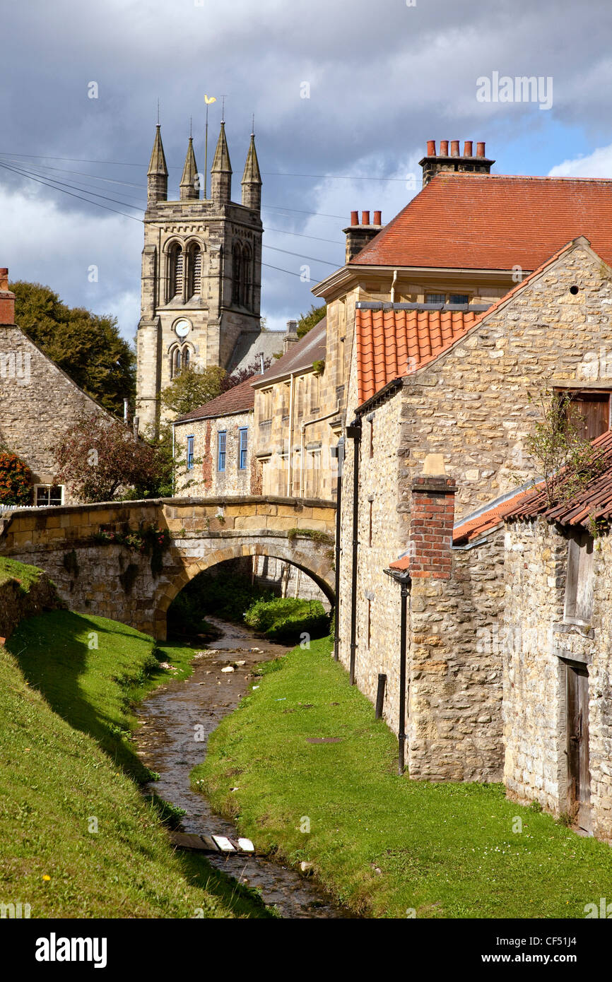 Blick entlang eines Baches in der Markt-Dorf Helmsley in Richtung All Saints Church. Stockfoto