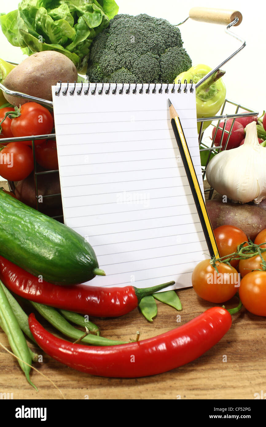 Korb mit frischem Gemüse, shopping-Liste und Bleistift auf einem hölzernen Hintergrund Stockfoto