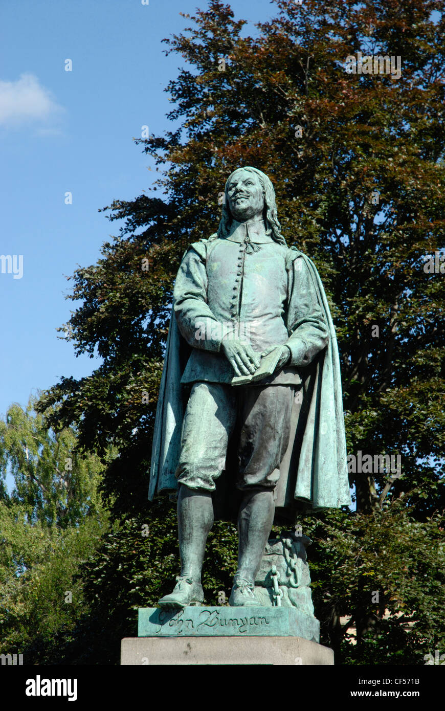 Bäume hinter einer Statue von John Bunyan in St. Peters Street. Stockfoto