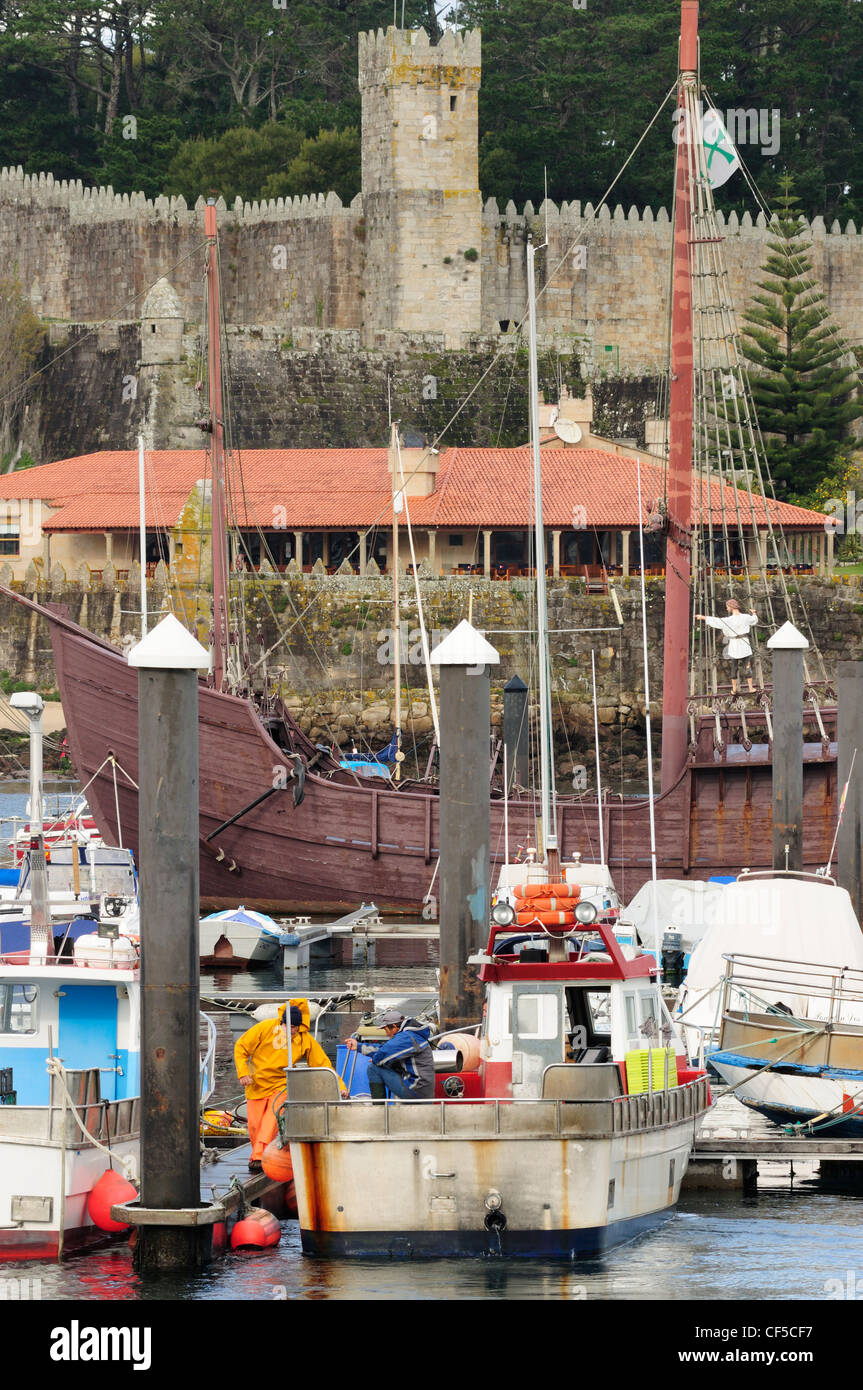 Traditionelle Fischerboote vor dem Monte Real Burg und La Pinta Karavelle. Baiona. Galicien, Spanien. Stockfoto