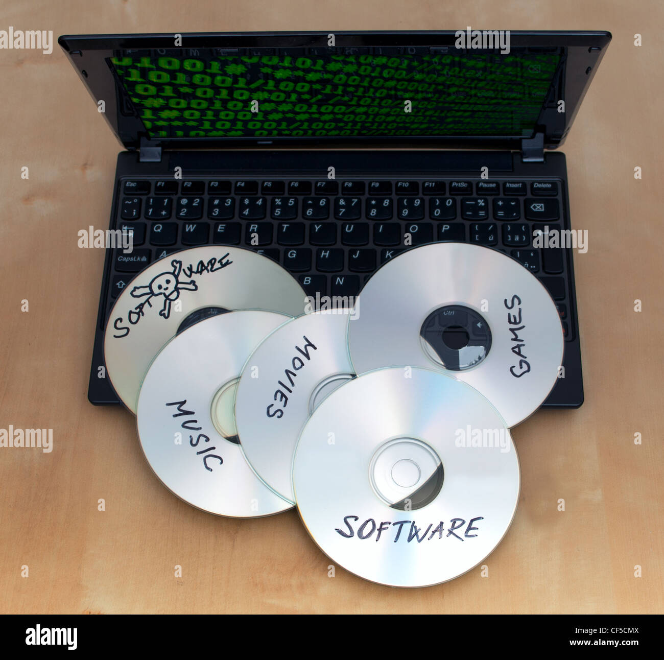 Piraterie-Konzept - gebrannte CDs mit illegaler Software auf Tastatur Notebook Stockfoto