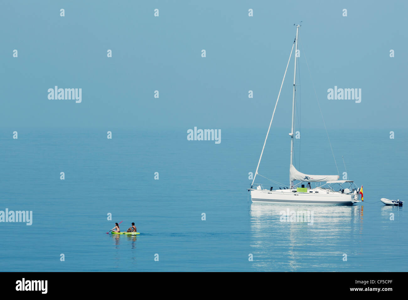 Junges Paar in der Nähe von verankerten Yacht Schlauchboot paddeln. La Herradura, Provinz Granada, Costa Tropical, Spanien. Stockfoto