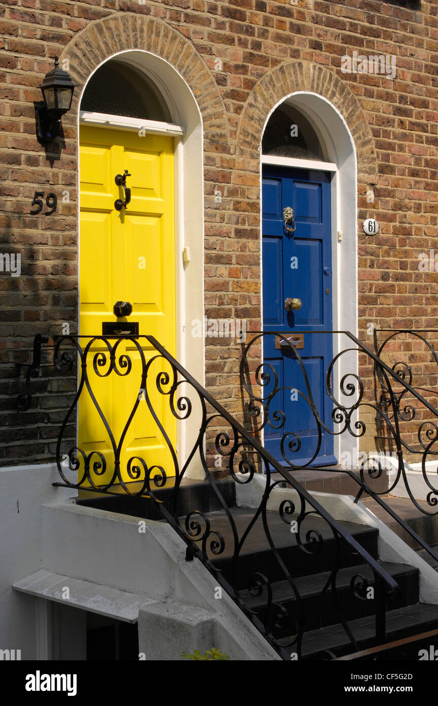 Hell blau und gelb bemalt vorderen Türen mit Schritten bis zu Haus und schmiedeeisernen Geländer Stockfoto