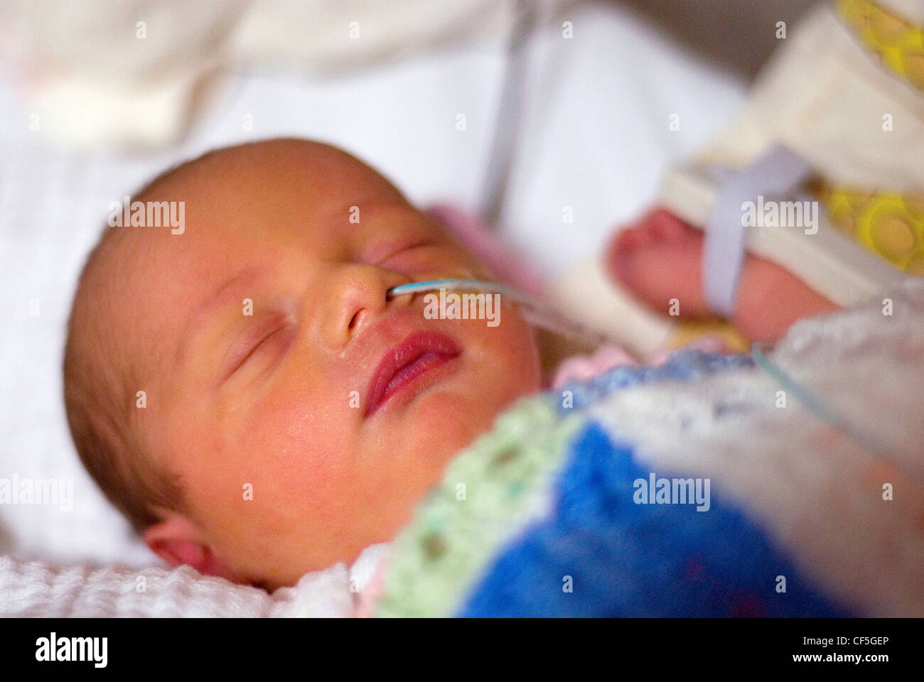 Neugeborenes Babymädchen schläft mit einem Schlauch in der Nase tragen eine  weiße und rosa babygrow Stockfotografie - Alamy