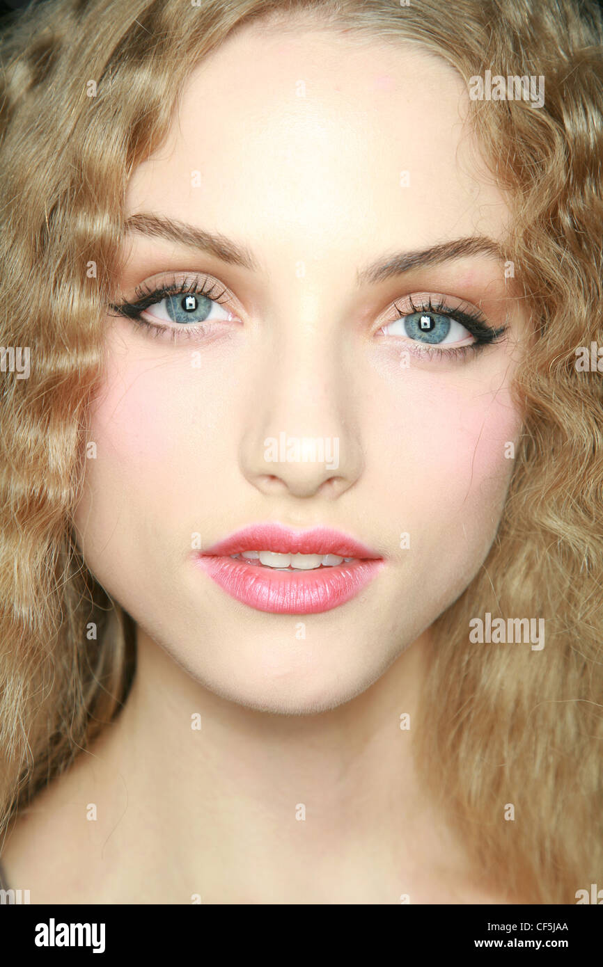 Modell mit langen blonden Haaren tragen fetten schwarzen Eyeliner, schwarze Wimperntusche, Lidschatten Beige, rosa Rouge und rosa Lippenstift Stockfoto