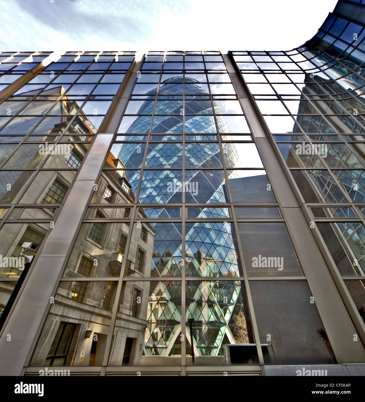 30 St Mary Axe spiegelt sich im Glasbau. Berüchtigt als "Gherkin" wegen seiner 3D ovale Form bekannt, ist es eines der ersten l Stockfoto