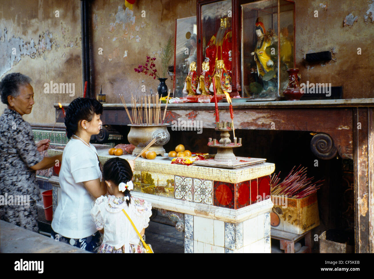 Singapur-Tempel-Chinesen beten drei Generationen Opfergaben Stockfoto