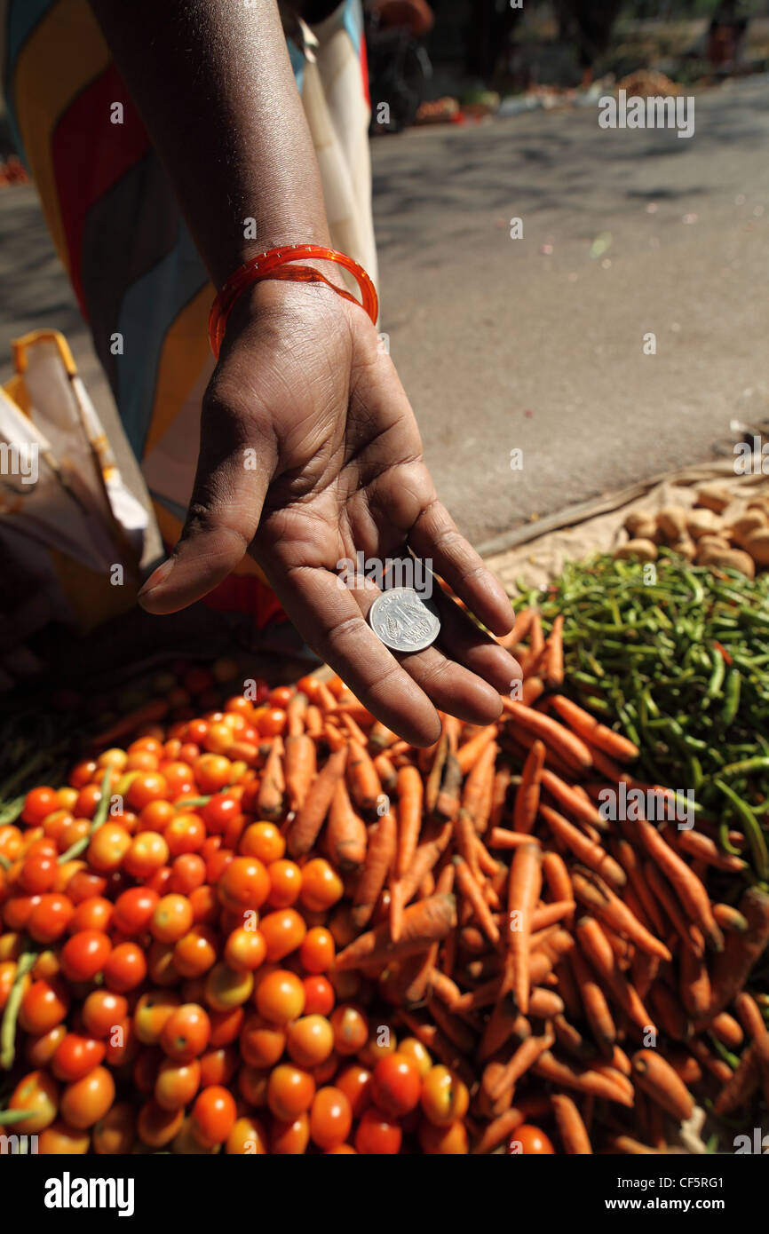 Käufer, die geben einer eine Rupie-Münze an dem Verkäufer Andhra Pradesh in Indien Stockfoto
