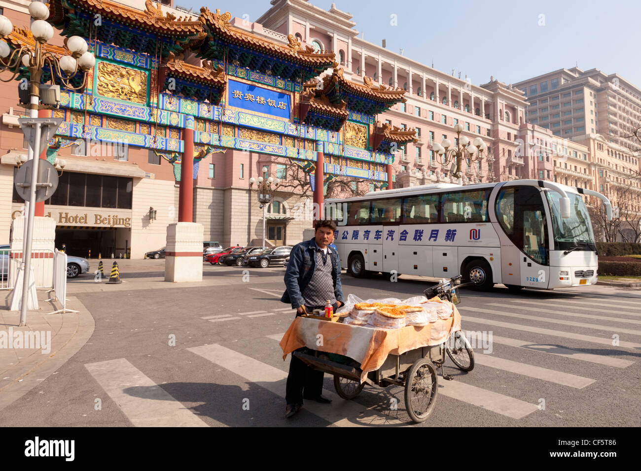 Eine Straße Nahrung Verkäufer verkaufen Pizza außerhalb zum Grand Hotel, Chang'an Avenue, Peking, China, Reisebus im Hintergrund. Stockfoto