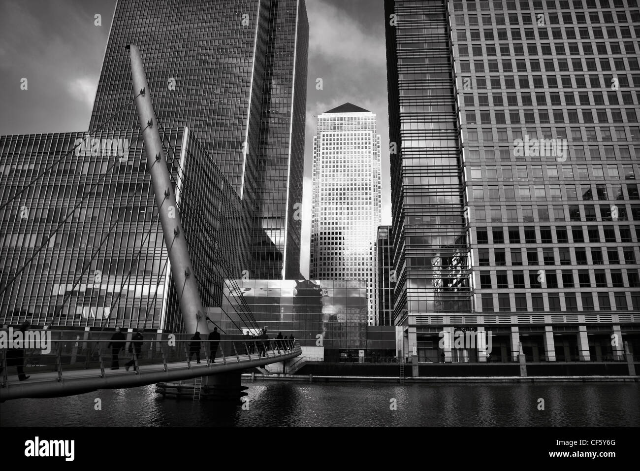 Blick über eine Fußgängerbrücke über die West India Millwall Docks gegenüber den Wolkenkratzern in Canary Wharf, Heimat der drei höchsten b Stockfoto