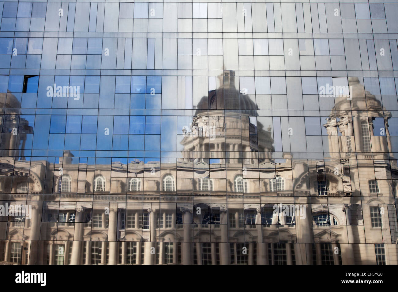 Der Hafen von Liverpool Gebäude spiegelt sich in der Glasverkleidung eines modernen Neubaus. Stockfoto