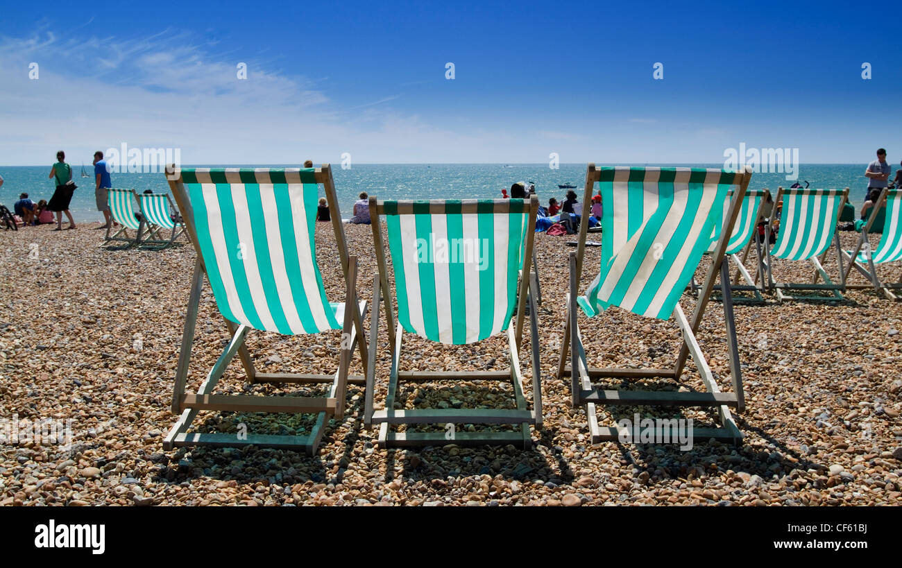 Liegestühle am Strand von Brighton. Stockfoto