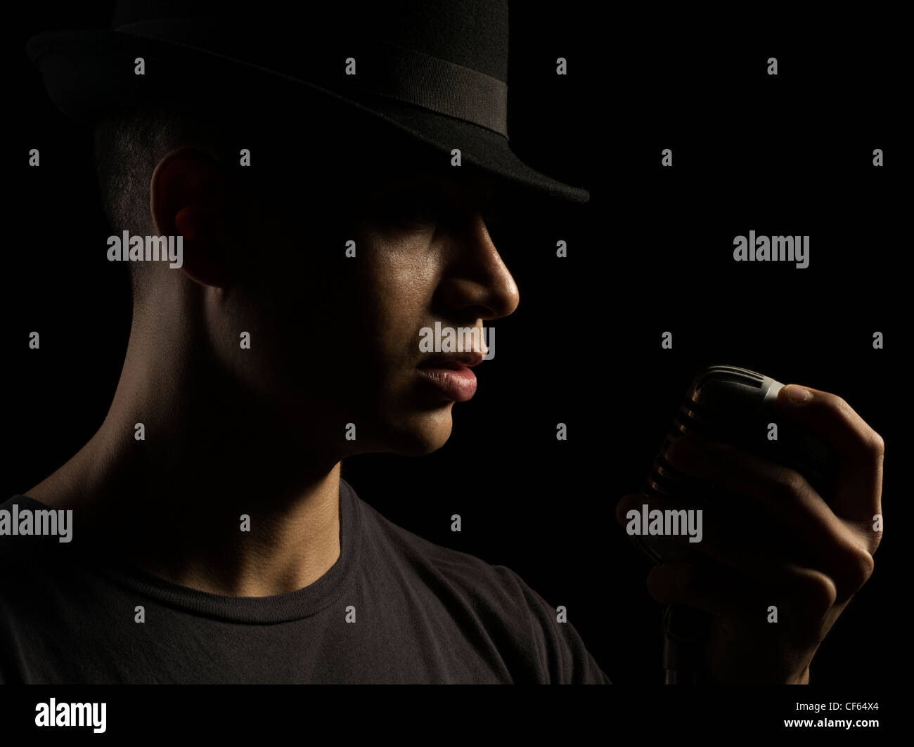 Sänger mit schwarzen Fedora Hut und Shure 55 Mikrofon Stockfoto