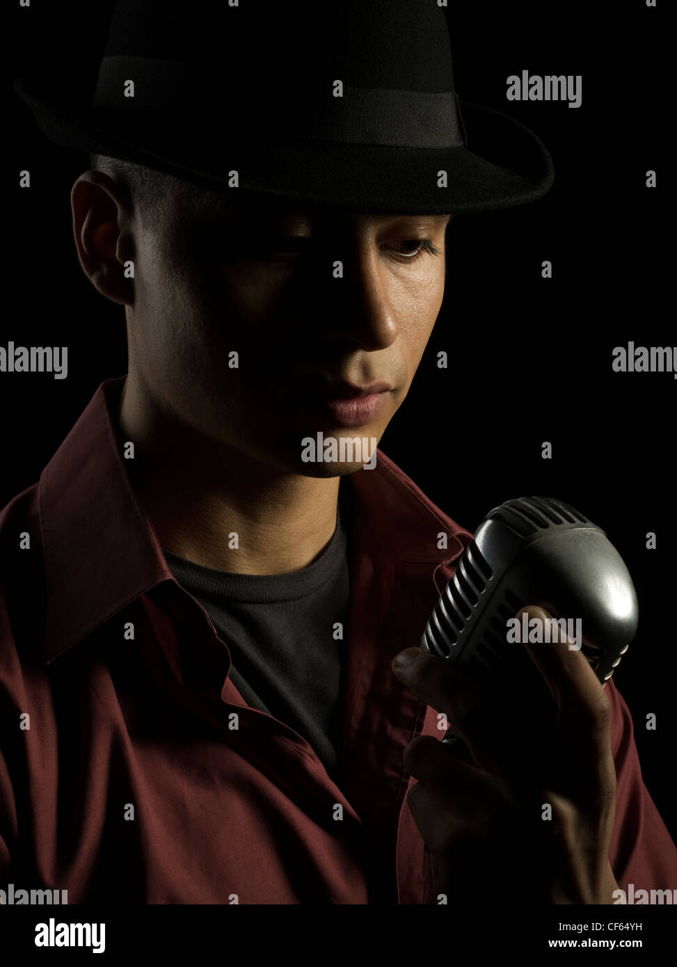 Sänger mit schwarzen Fedora Hut und Shure 55 Mikrofon Stockfoto