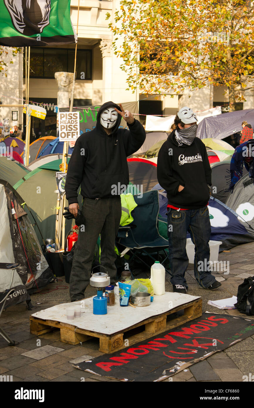 Ein Demonstrant besetzen London zeigen Friedenszeichen im stehen mit anderen Demonstranten inmitten der Zelte vor der St. Paul Kathedrale Stockfoto