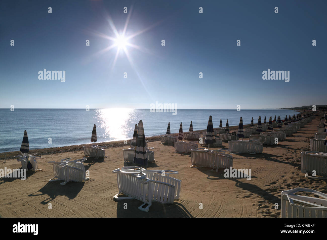 Sonnenliege mit Sonnenschirmen sind morgen bei Sonnenaufgang am Strand erbaute Stockfoto