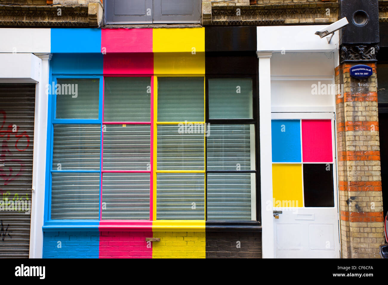 Bunte Ladenfront und Fenster, dekoriert mit CMYK (Cyan, Magenta, gelb und schwarz) Streifen und Quadrate. Stockfoto