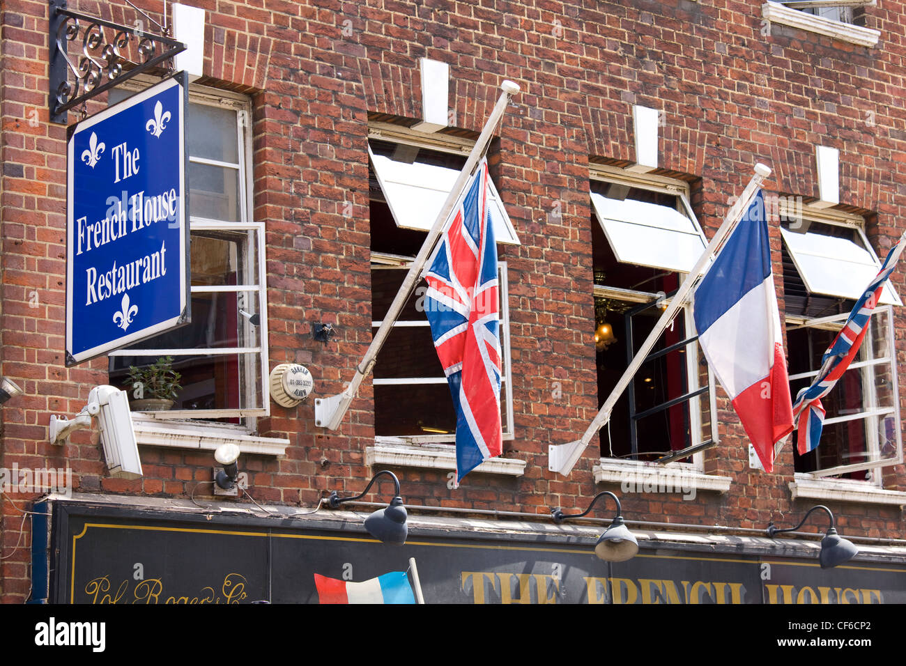 Union Flaggen und eine französische Trikolore fliegt vor dem französischen House Restaurant in Dean Street, Soho. Stockfoto