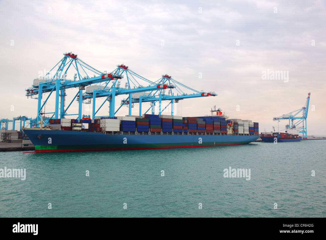 Großen Frachtboot und kleinen Lastkahn angedockt, Industriehafen mit blauen Kränen Stockfoto
