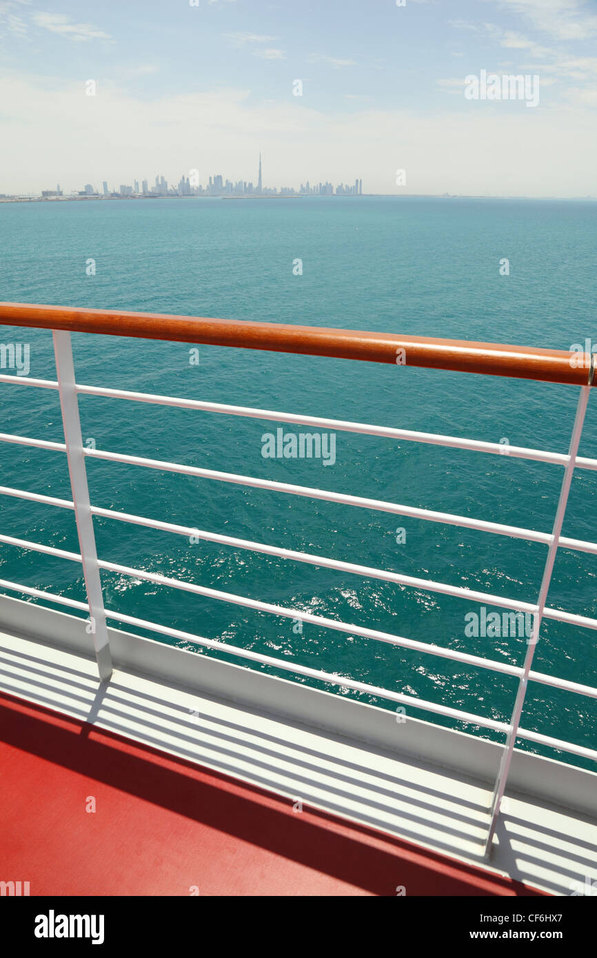 Cruise Liner Deck mit rot und hölzernen Schienen, sonnigen Tag, Stadt am Horizont Stockfoto