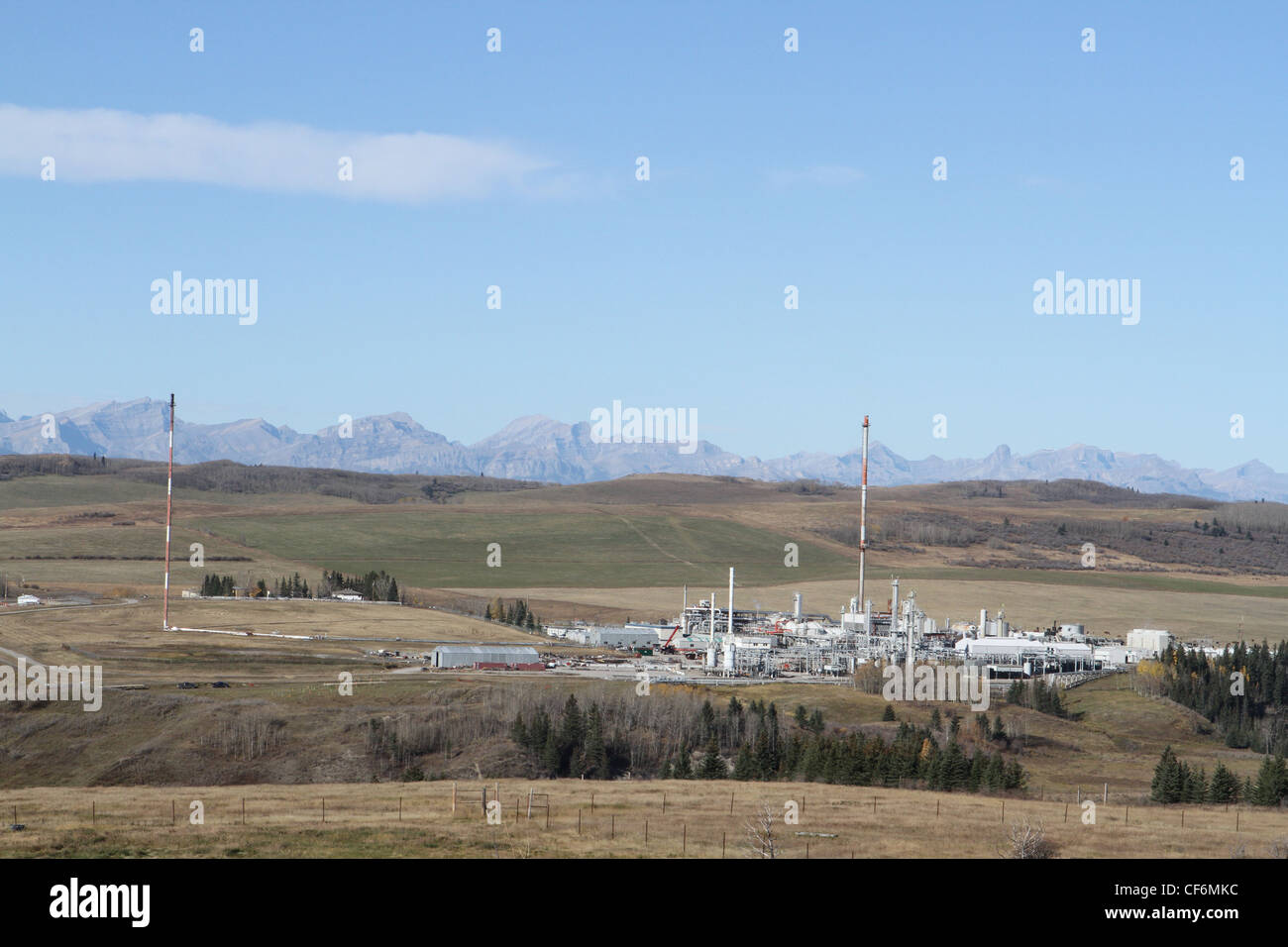 Erdgas-Aufbereitungsanlage in der Nähe von den kanadischen Rocky Mountains mit den Rockies am Horizont Stockfoto