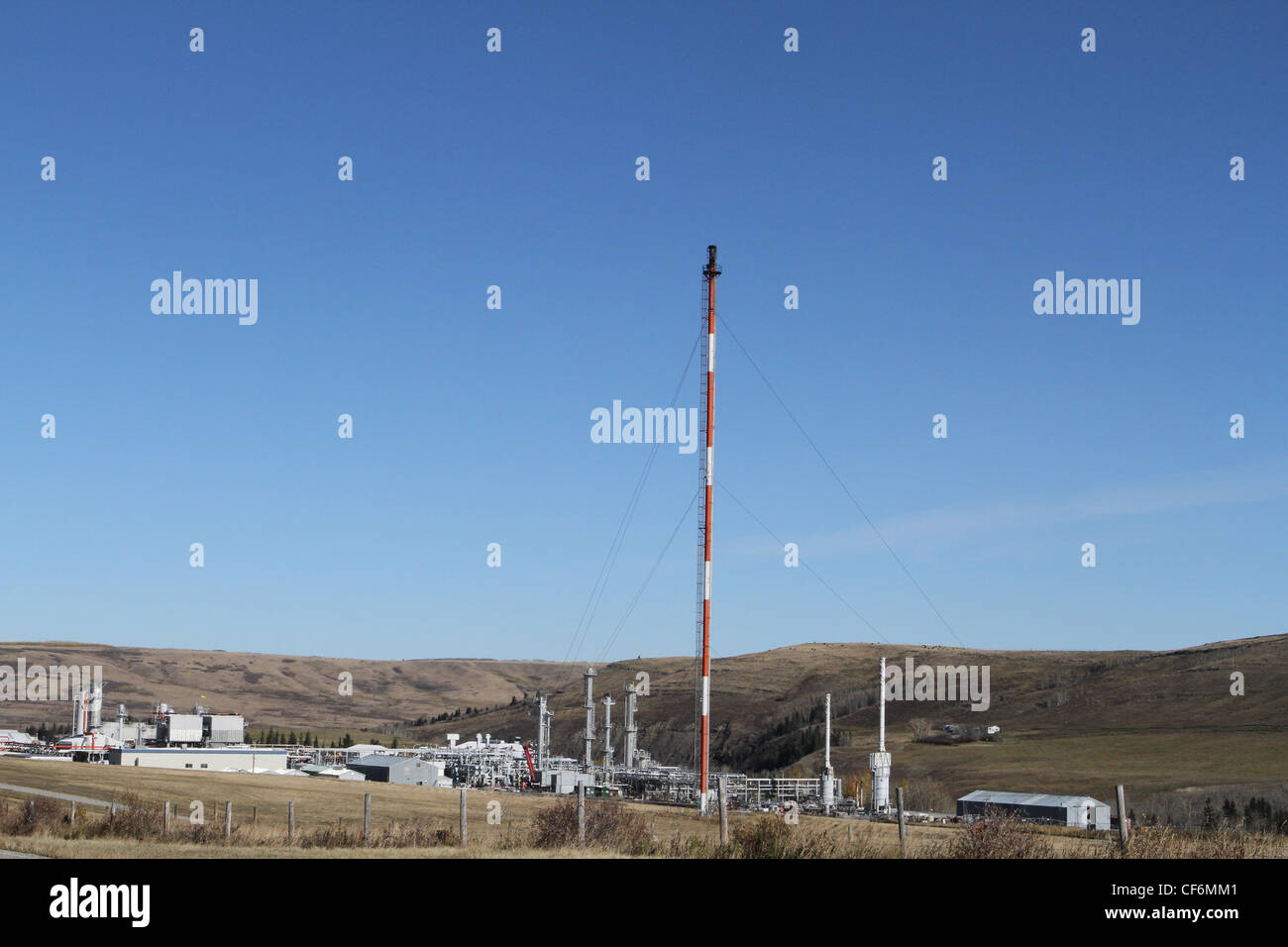 Erdgas-Aufbereitungsanlage in der Nähe von den kanadischen Rocky Mountains mit den Rockies am Horizont Stockfoto