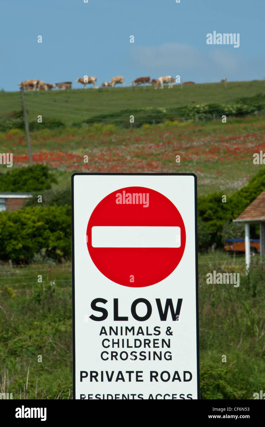 A Tiere & Kinder überqueren Straßenschild zu verlangsamen. South Downs Sussex England Stockfoto