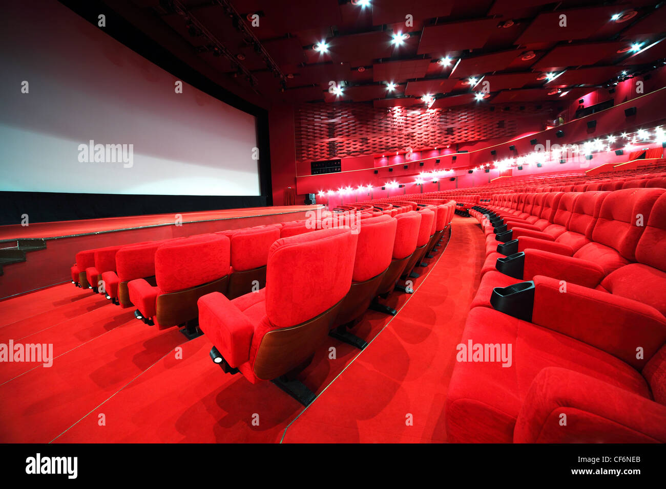 Blick vom Treppen auf Reihen von bequemen roten Sesseln in leuchten rote Zimmer Kino Stockfoto